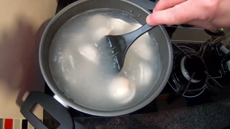 Woman-stirring-with-a-spatula-in-a-red-pot,-Italian-pasta