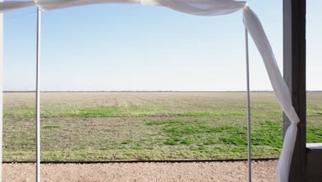 aerial-view-of-drone-going-through-outdoor-wedding-chapel-in-countryside-4K