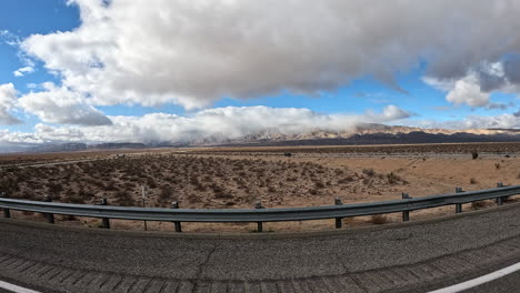 driving through the mojave desert's rugged terrain on a highway as seen from the passenger window