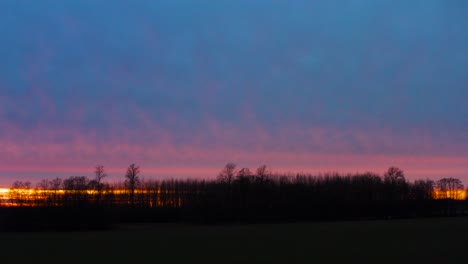 Colorida-Ilusión-De-Nube-De-Puesta-De-Sol-De-Hora-Dorada-En-El-Cielo-Con-Silueta-De-Bosque-Oscuro