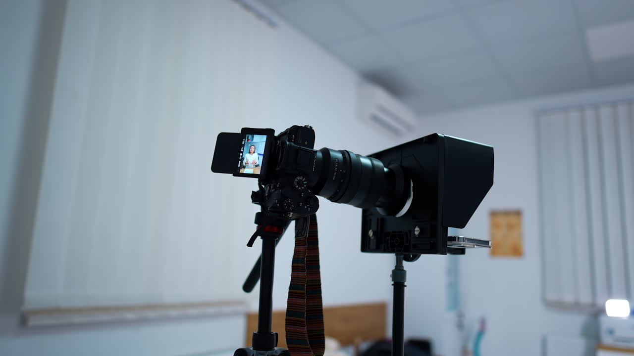 Camera on tripod with a woman speaking on the display. Professional equipment used in blog content creation.