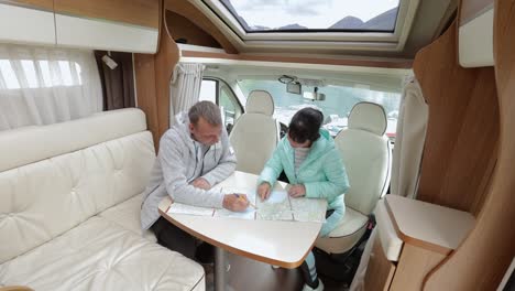 couples in rv camper looking at the local map for the trip.