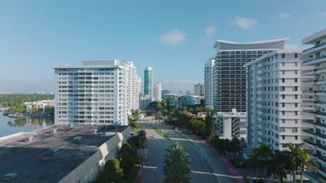 Forwards-fly-above-multilane-trunk-road-leading-through-urban-borough-with-luxurious-multistorey-apartment-buildings.-Miami,-USA