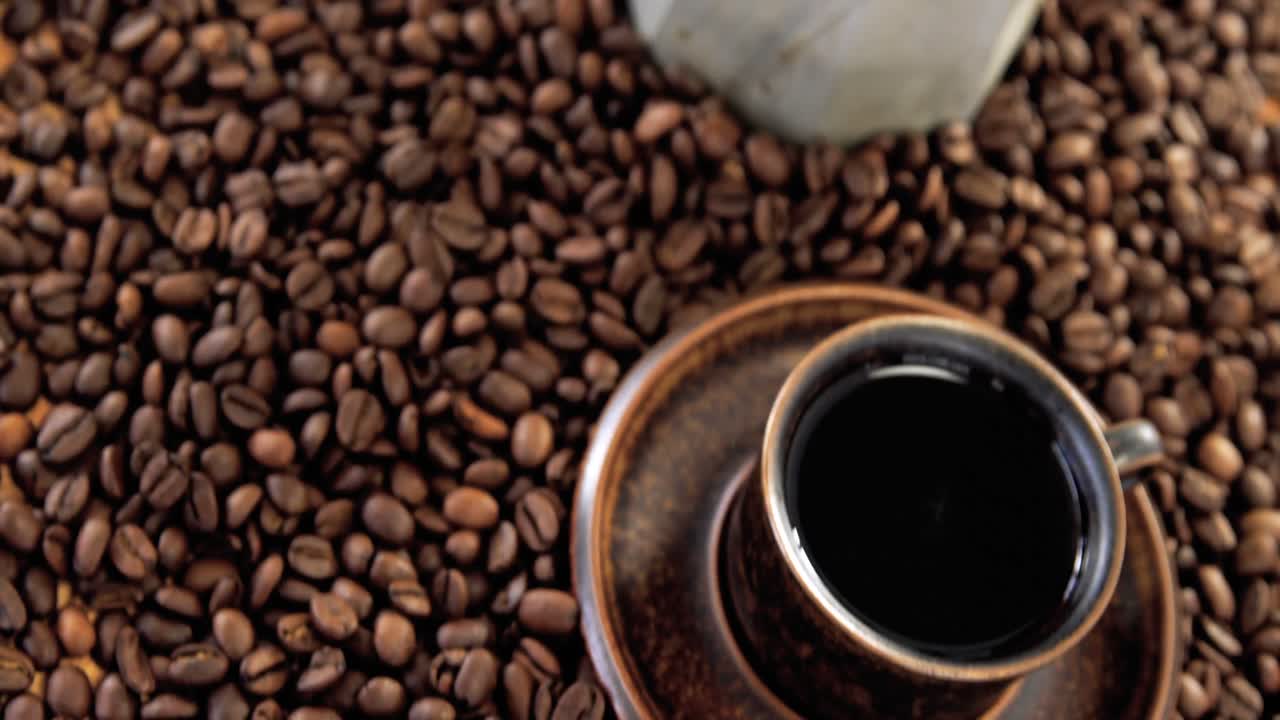cafetera con granos de café y taza de café