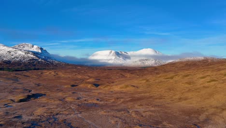 aerial rising shot of snow covered mountains in the glencoe mountain range