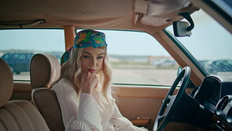 relaxed girl sitting auto in colorful bandanna close up. blonde posing retro car