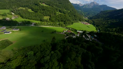 FPV-drone-diving-in-a-green-mountain-and-flying-over-a-river-with-turquoise-water-in-Austria