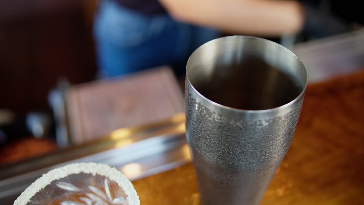 Barmen, taze bir içecek hazırlarken kokteyl çalkalayıcıya ahududu ekliyor