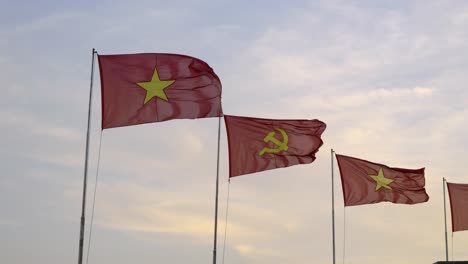 vietnamese and communist flag waving in slow motion against cloudy sky