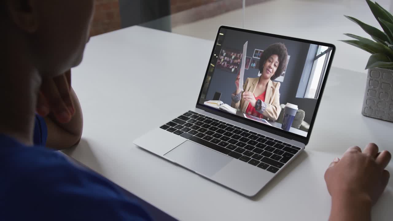 Mid section of african american woman having a video call with female colleague on laptop at office
