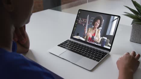 Mid-section-of-african-american-woman-having-a-video-call-with-female-colleague-on-laptop-at-office