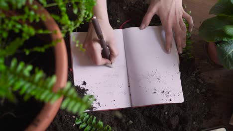 Recyclingpapier-Und-Umweltschutzkonzept,-Person-Macht-Sich-Notizen-In-Einem-Notizbuch,-Das-Aus-Wiederverwendeten-Materialien-Hergestellt-Wurde