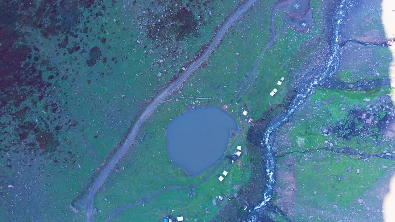 Aerial view of Chinar Lake nestled in Surgen Valley near Noori Top amid alpine terrain. Pakistan