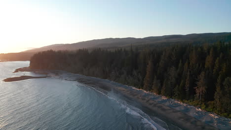 drone over a beach and trees on vancouver island in sooke, british columbia canada at sunset