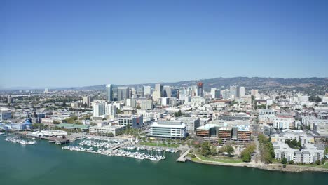 A-beautiful-sunny-day-as-the-camera-passes-over-the-city-with-bright-buildings-and-a-clear-blue-sky