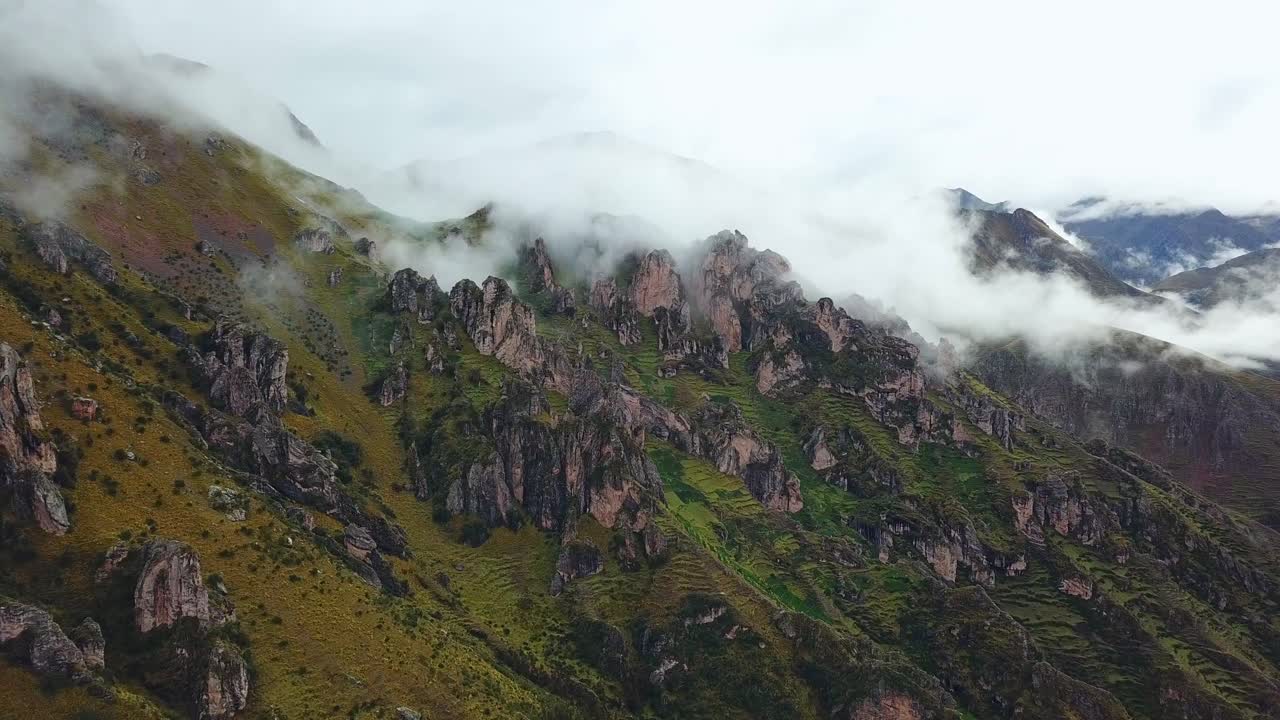 aéreo, en ascenso, disparo de drones hacia formaciones rocosas en las montañas de los andes brumosos, en un día nublado, cerca de cusco, en perú, américa del sur