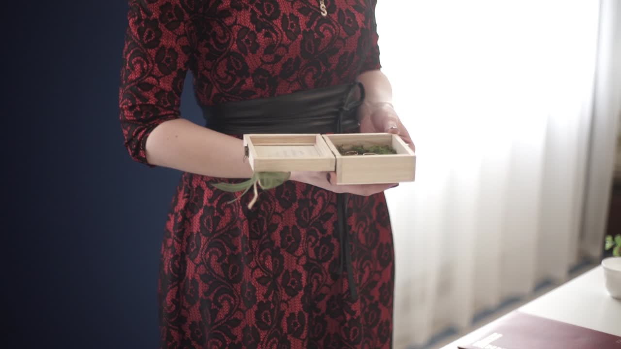 빨간 드레스 를 입은 나무 반지 상자 를 들고 있는 여자