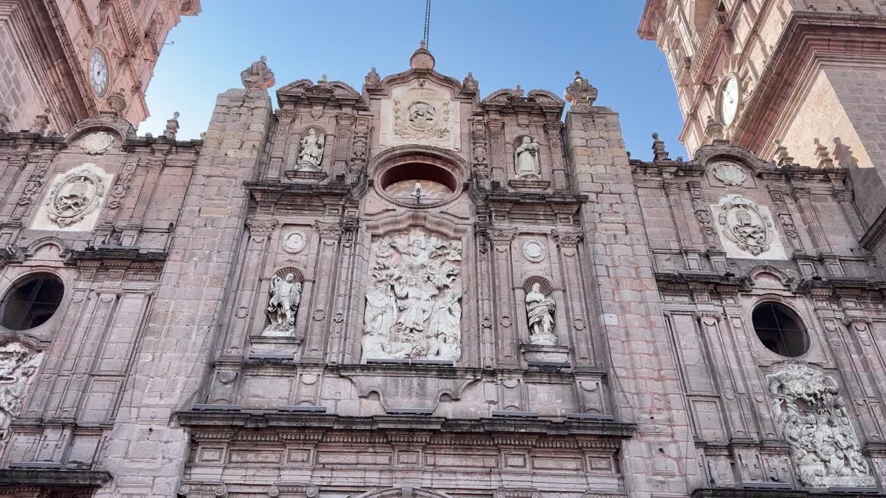 Primo piano dettagliato di sculture e statue barocche in pietra ornate sulla facciata della Cattedrale di Morelia, che evidenzia l'architettura coloniale spagnola nel Michoacán.