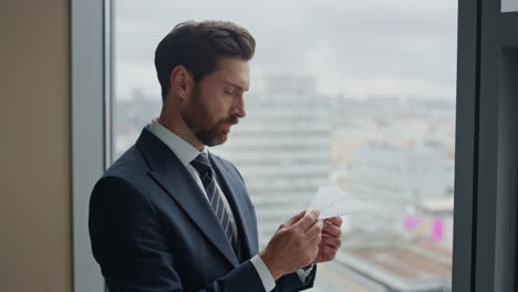 Entrepreneur-making-paper-airplane-thinking-on-aviation-business-close-up.