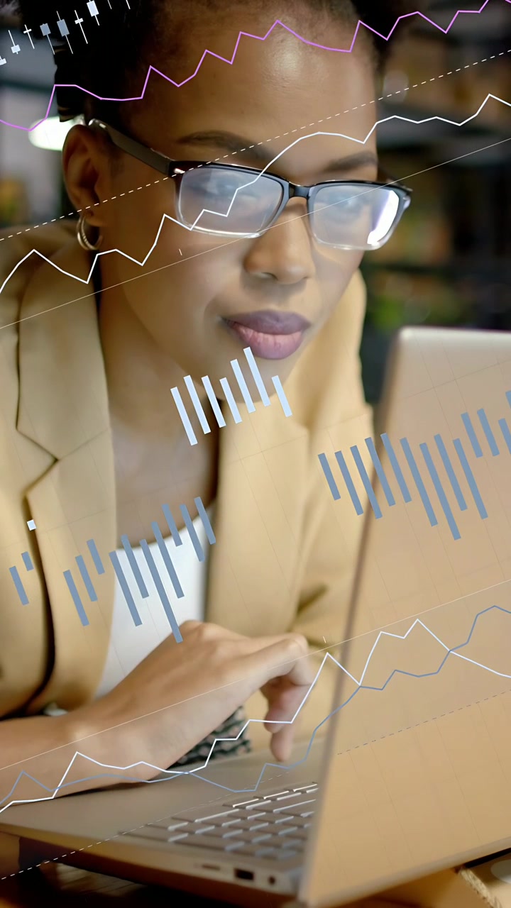 Vertical video: Woman typing on laptop and initiating chart overlays, analyzing business metrics