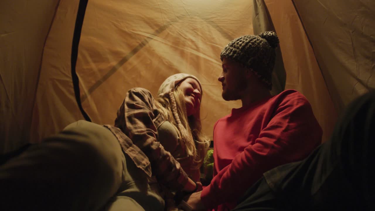 pareja caucásica acampando en la naturaleza por la noche