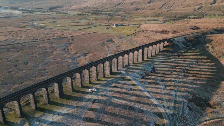 Railway bridge slow partial orbit revealing winter moorland with long shadows at Ribblehead Viaduct