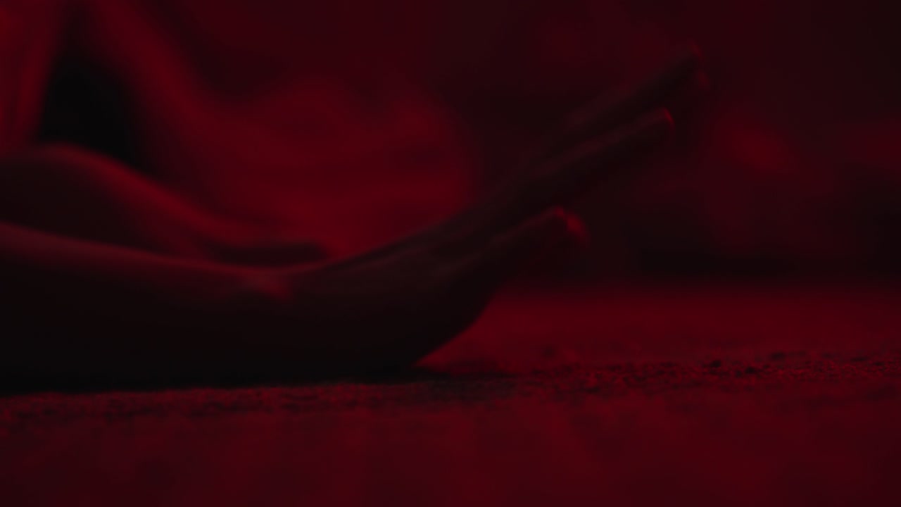 A tense and dramatic shot of a woman falling to the floor, extending her hands for help. The moody lighting and emotional intensity make it ideal for thriller, horror, or psychological short films