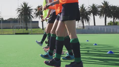 female hockey players exercising on the field