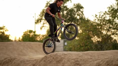 bmx rider performing tricks in a dirt jump park
