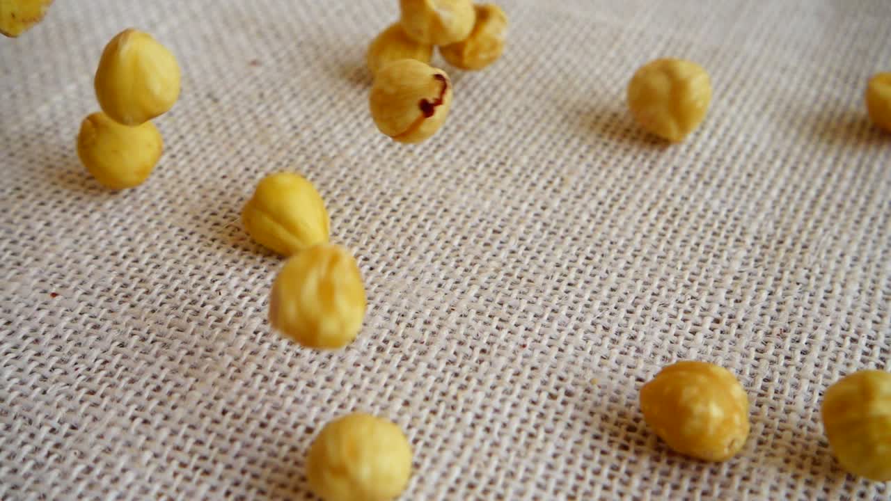 Nocciole. Riprese mentre cadono su un sacco. Movimento rallentato