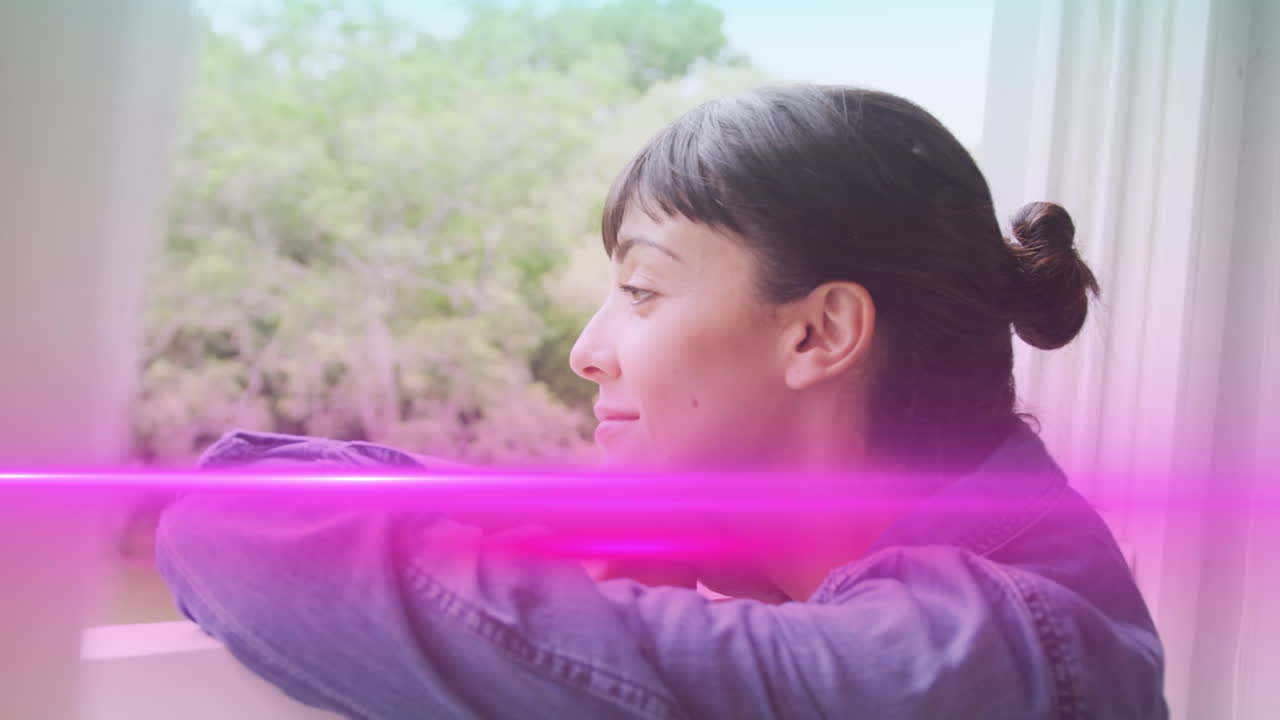 미소 짓고 집의 창문을 통해 바라보는 사려 깊은 백인 젊은 여성 위에 분홍색  ⁇ 어 라인