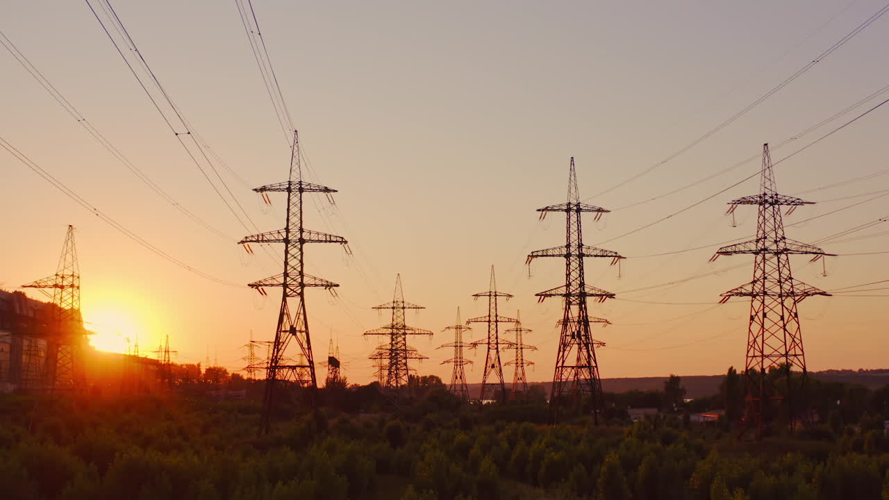 High voltage electric towers at sunset. Transmission power line. Parts of electrical equipment and high voltage power line insulators in the evening.