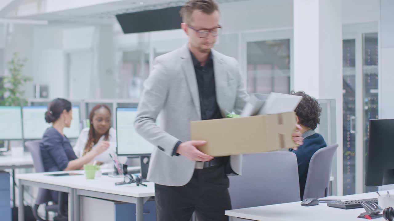 職場から解雇されたオフィスワーカーは自分の持ち物を紙箱に入れてオフィスを去ります 労働力削減縮小再編再編成アウトソーシング大量失業市場危機