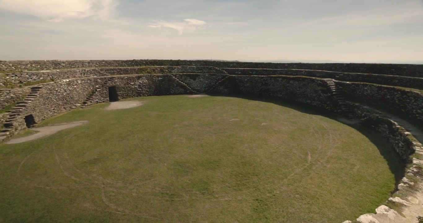 Inquadratura lenta e rivelatrice dell'interno erboso del Grianan di Aileach.