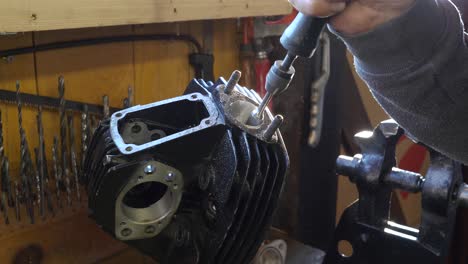 caucasian worker uses honing tool to work on an engine block, detail of hand