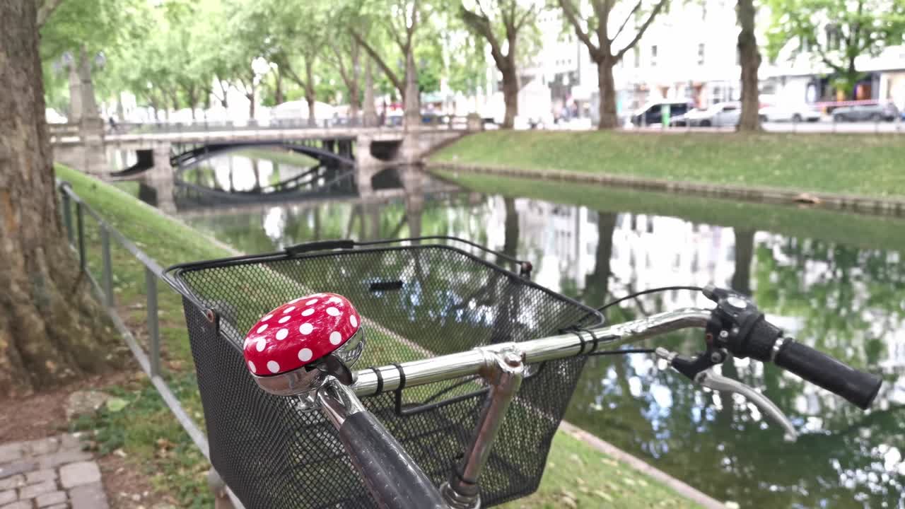 Bike with bell in mushroom look in front of the backdrop of the moat Düsseldorf at Königsallee