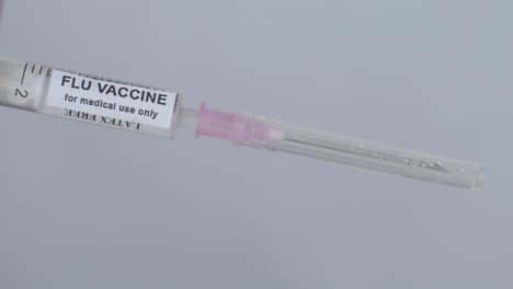 doctor's hand attaching needle to syringe - flu vaccine - close up