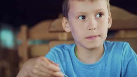 young boy eating ice-cream with spoon. kid eats delicious dessert