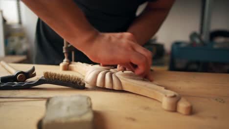 craftsman polishing wooden detail in workshop