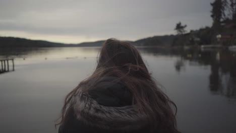 mujer sentada junto al lago