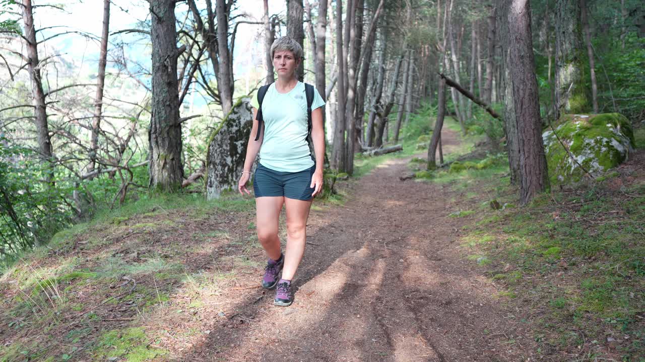 Mulher caminhando na trilha da floresta