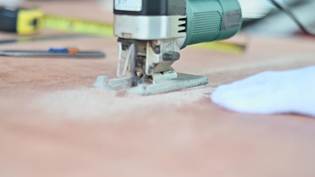 The carpenter used a woodworking saw to cut plywood.