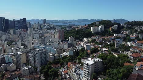 favelas and houses with the sea and mounts on the background - daylight landscape by drone in rio de janeiro