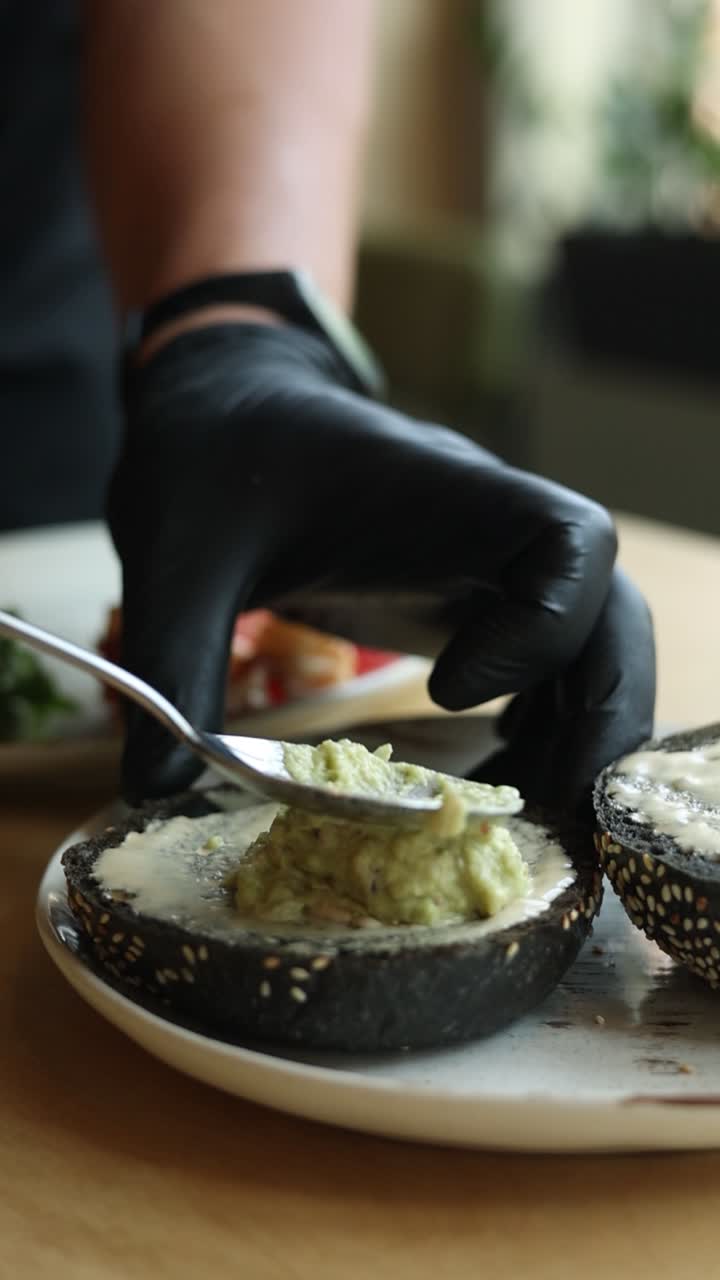 chef preparando un delicioso aguacate esparcido en un pan negro