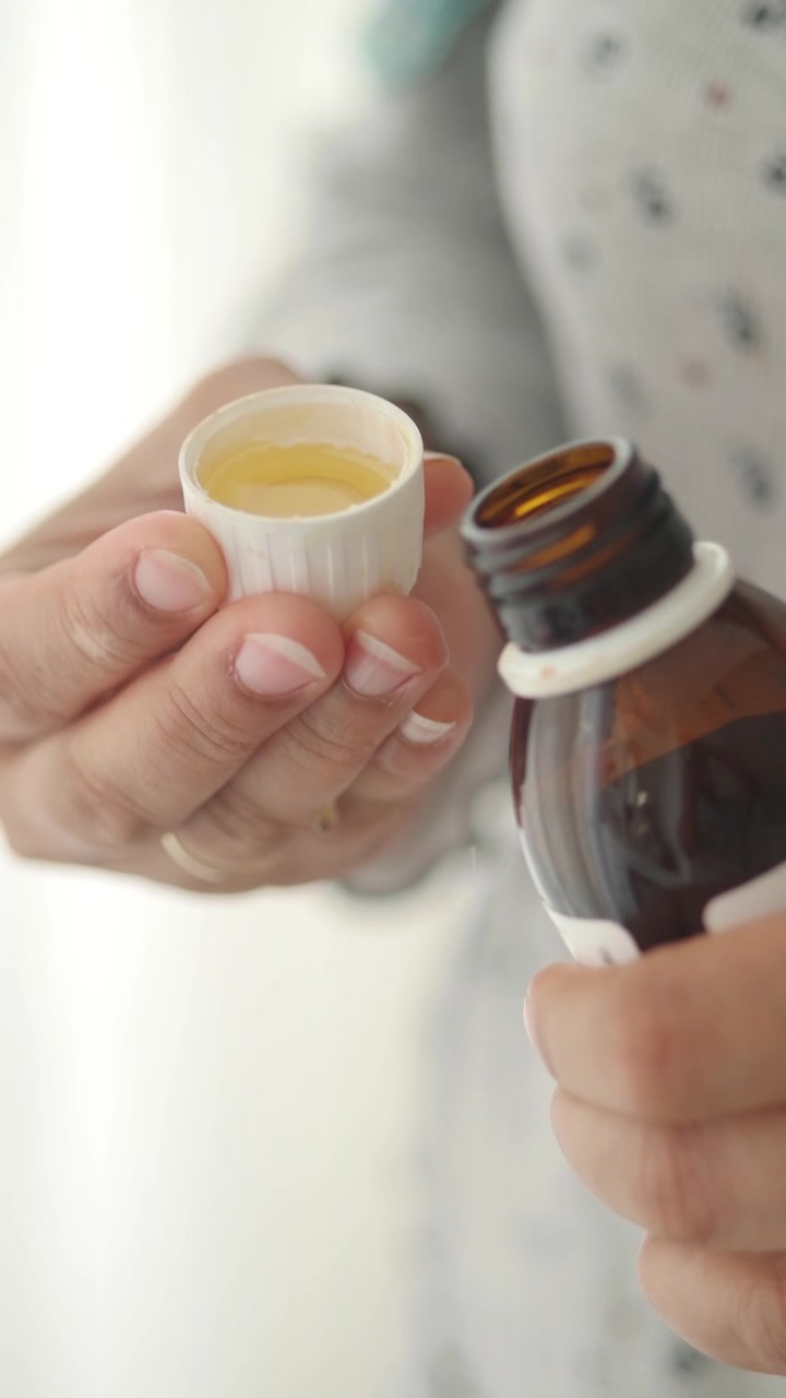 Persona Vertiendo Medicina Líquida en una Taza Medidora