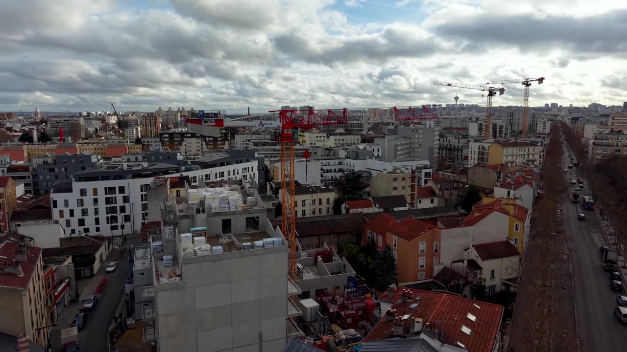 Grúas de construcción trabajando en nuevos edificios en la ciudad de París, Francia. Vista aérea con dron.