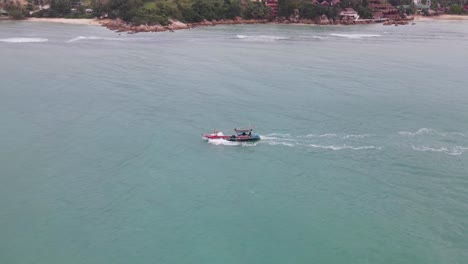 Vista-Aérea-Del-Barco-Pesquero-Navegando-Con-Retroceso-Para-Mostrar-La-Isla-De-Koh-Phangan-En-Segundo-Plano.