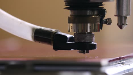 a mechanical braille drill bores holes to be filled with braille engraving in slow motion