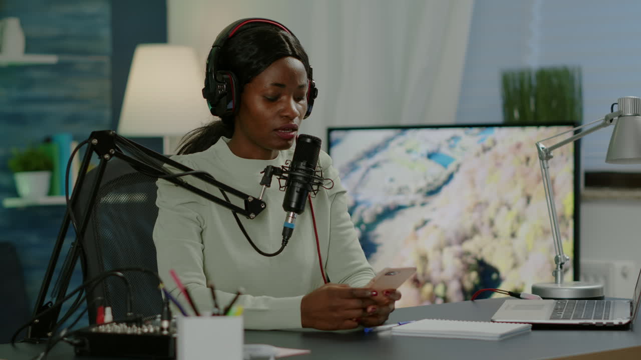 African blogger woman reading messages on smartphone