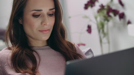 rostro de mujer sonriente mirando la pantalla del portátil. mujer de negocios en casa